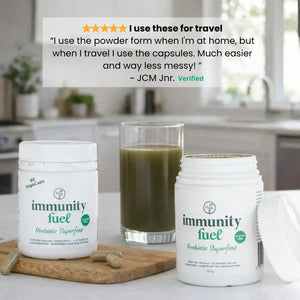 Two containers of 'immunity fuel' with a glass of green juice on a kitchen counter featuring a customer review