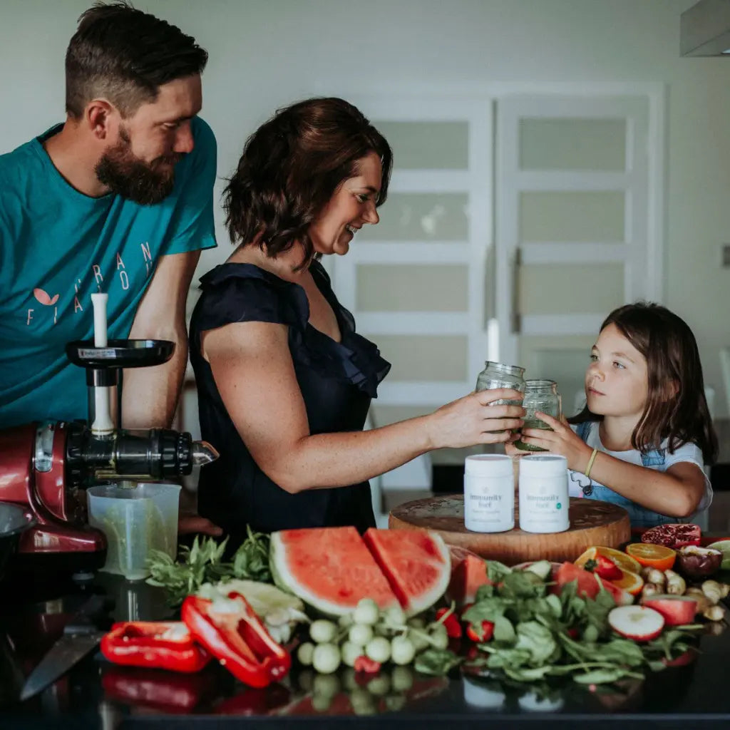 Family in a kitchen preparing food with fruits and vegetables and immunity fuel probiotic superfoods on a table.