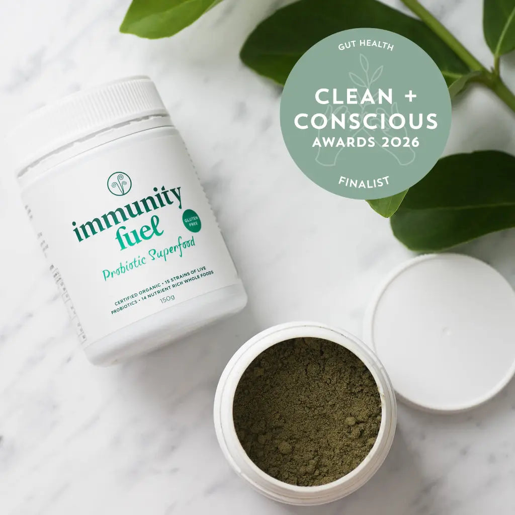 Container of 'Immunity Fuel' probiotic superfood with green powder on a marble surface, featuring 'Clean + Conscious Awards 2026' label.