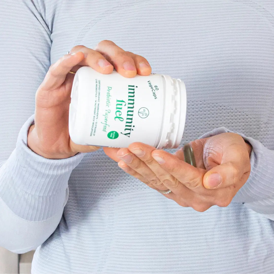 Woman holding a white immunity fuel capsules container 